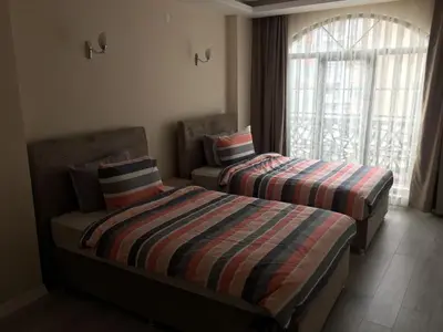 two beds in a room with a window at STS Hotel Luleburgaz in Lüleburgaz