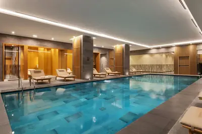 a large swimming pool in a hotel with lounge chairs at Marriott Executive Apartments Istanbul Investvadi in Istanbul