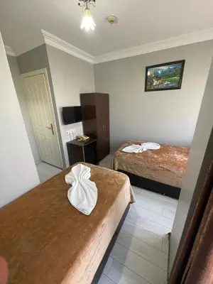 a hotel room with two beds and a table at Hotel Grand Ömer in Istanbul