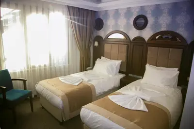 a hotel room with two beds and a chair at Golden Pen Hotel in Istanbul