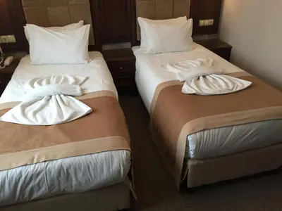 two beds in a hotel room with towels on them at Golden Pen Hotel in Istanbul