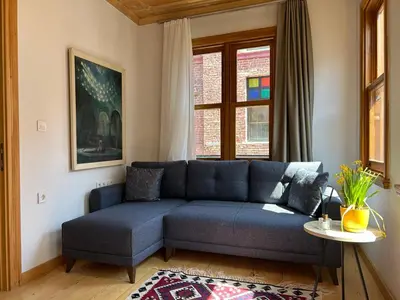 a blue couch in a living room with a window at Balat Rose - Charming Wooden House with Terrace in Istanbul