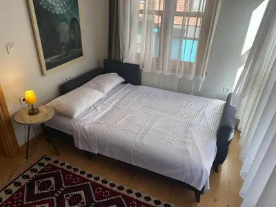 a bed in a bedroom with a lamp on a table at Balat Rose - Charming Wooden House with Terrace in Istanbul