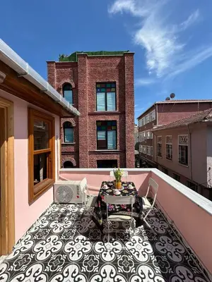 a balcony with a table and chairs on a building at Balat Rose - Charming Wooden House with Terrace in Istanbul