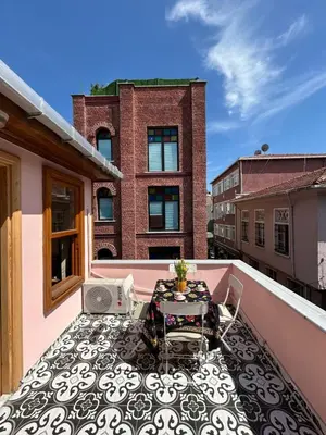a balcony with a table and chairs on a building at Balat Rose - Charming Wooden House with Terrace in Istanbul