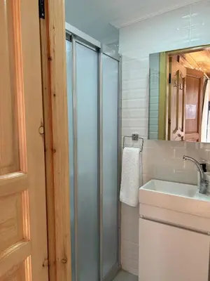 a bathroom with a glass shower and a sink at Balat Rose - Charming Wooden House with Terrace in Istanbul
