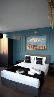 a bedroom with a large bed with a painting on the wall at Hmz Premium Konaklama Çekmeköy in Çekmeköy