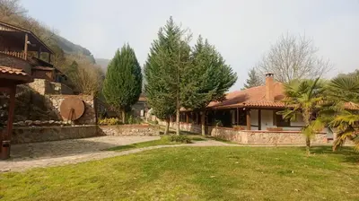 a house with a yard with trees and a building at Değirmenbaşı Otel & Restoran in Ümmiye