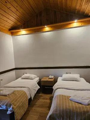 two beds are in a room with at Değirmenbaşı Otel & Restoran in Ümmiye