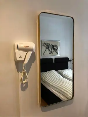 a mirror with a phone next to a bed at Starmax City's Hotel YALOVA in Kâzımiye