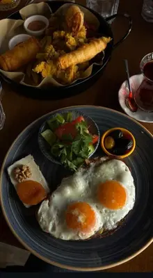 a plate with two fried eggs and a plate of food at Starmax City's Hotel YALOVA in Kâzımiye