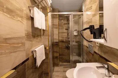 a bathroom with a shower and a toilet and a sink at Quinnova Hotel in Istanbul