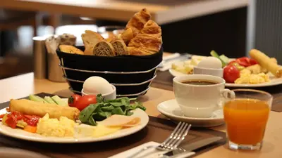 a table with plates of food and a basket of bread at The Galata Glory Hotel in Istanbul