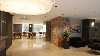a dining room with a table and a large stone wall at The Galata Glory Hotel in Istanbul