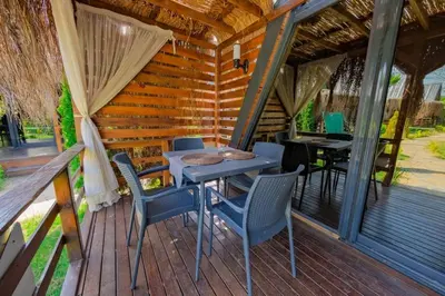 a patio with a table and chairs on a deck at Kerpe Bungalov Hotel in Kocaeli