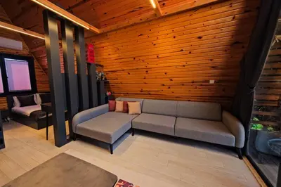 a living room with two couches and a wooden wall at Kerpe Bungalov Hotel in Kocaeli
