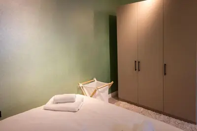 a bedroom with a white bed and a cabinet at Modern & Stylish 2BR Haven by the Sea in Yedikule in Istanbul