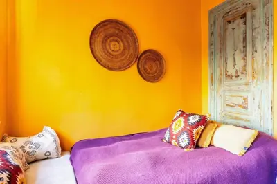 a yellow wall with pillows on a bed in a room at Historic Balat 2BD2Bath Central House! #388 in Istanbul