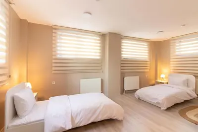 a bedroom with two beds and windows with blinds at Beautifully Designed 3BR Duplex in Prime Göktürk in Kemerburgaz