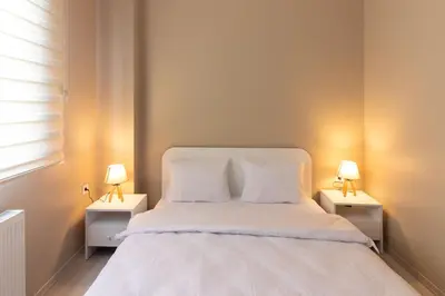 a bedroom with a white bed with two night stands at Modern 1BR with Elegant Design in Göktürk in Kemerburgaz