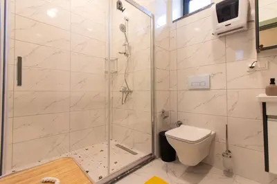 a bathroom with a shower and a toilet at Modern 1BR with Elegant Design in Göktürk in Kemerburgaz