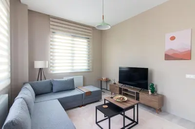 a living room with a blue couch and a tv at Modern 1BR with Elegant Design in Göktürk in Kemerburgaz
