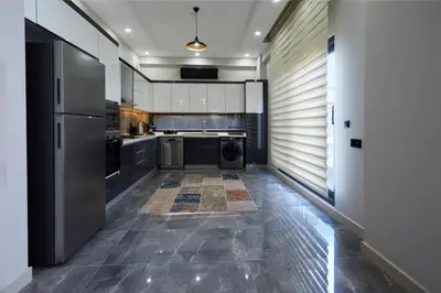 a kitchen with stainless steel appliances and a tile floor at Andalus Villas Lake View NO ALCOHOL ALLOWED with Heated Pool in Sakarya
