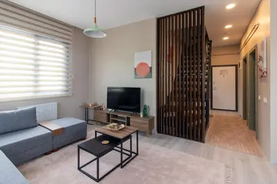 a living room with a blue couch and a tv at Göktürk's Finest 2BR Stylish, Spacious & Prime in Kemerburgaz