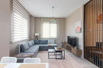 a living room with a blue couch and a tv at Göktürk's Finest 2BR Stylish, Spacious & Prime in Kemerburgaz
