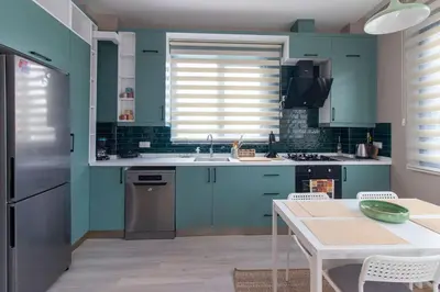 a kitchen with blue cabinets and a table at Göktürk's Finest 2BR Stylish, Spacious & Prime in Kemerburgaz
