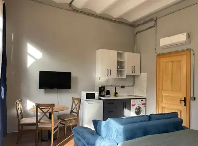 a living room with a blue couch and a kitchen at Soil balat in Istanbul