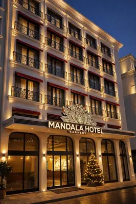 a large hotel with a christmas tree in front of it at Mandala Karaköy Hotel in Istanbul