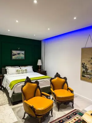 a bedroom with a bed and two yellow chairs at Sel Maison in Istanbul