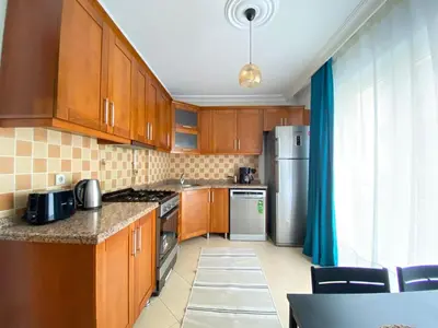 a kitchen with wooden cabinets and a stainless steel refrigerator at City Center 3 Bedroom Flat - No4 in Istanbul