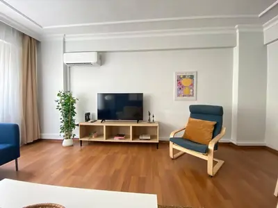a living room with a tv and a blue chair at City Center 3 Bedroom Flat - No4 in Istanbul