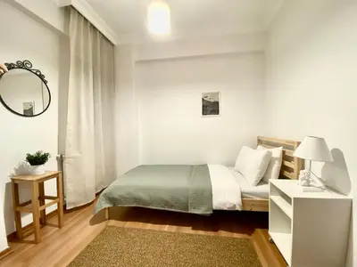 a white bedroom with a bed and a mirror at Central & Spacious Flat - No5 in Istanbul