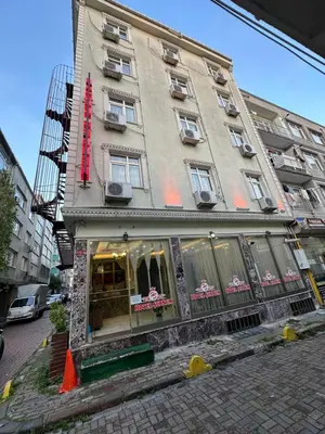 a building with a red sign on the side of it at Şebnem Hotel in Istanbul