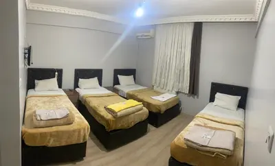 a room with three beds in a room at Şebnem Hotel in Istanbul