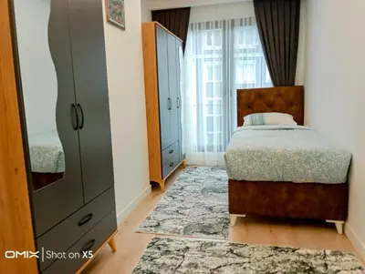 a bedroom with a bed and a dresser at Luxury Rezidans in Istanbul