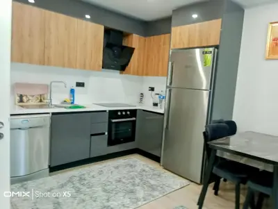 a kitchen with a stainless steel refrigerator and a table at Luxury Rezidans in Istanbul