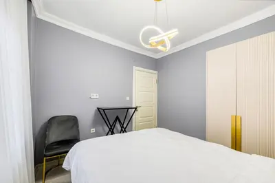 a bedroom with a white bed and a black chair at Bright Apart Hotel in Istanbul