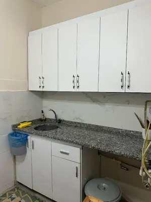 a white kitchen with a sink and white cabinets at Hostel Nelly in Istanbul