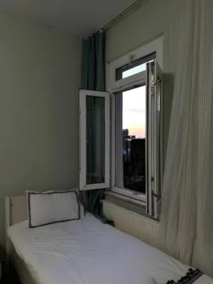 a bedroom with a bed and an open window at Hostel Nelly in Istanbul