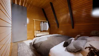 a bedroom with a bed with a wooden wall at Redka Bungalov Resort in Ulupelit