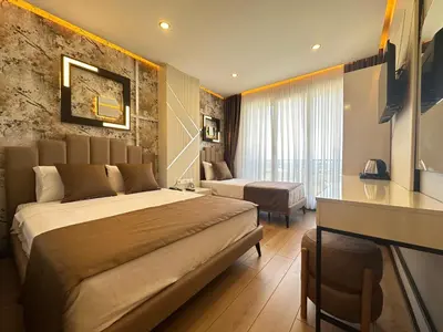 a hotel room with a large bed and a desk at Fourpoints Airport Hotel in Arnavutköy