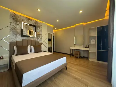 a bedroom with a large bed and a desk at Fourpoints Airport Hotel in Arnavutköy