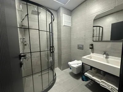a bathroom with a shower and a sink and a toilet at Fourpoints Airport Hotel in Arnavutköy