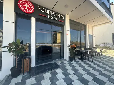 a four winds hotel with a table outside of it at Fourpoints Airport Hotel in Arnavutköy