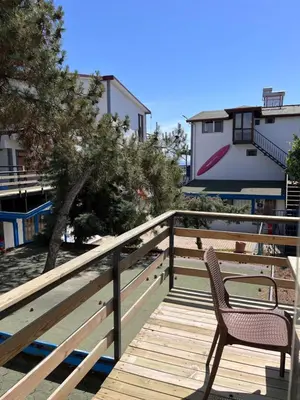 a chair sitting on a wooden deck next to a tree at Enn Is Inn Hotel in Marmaraereglisi