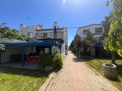 a brick walkway leading to a building with a blue roof at Enn Is Inn Hotel in Marmaraereglisi